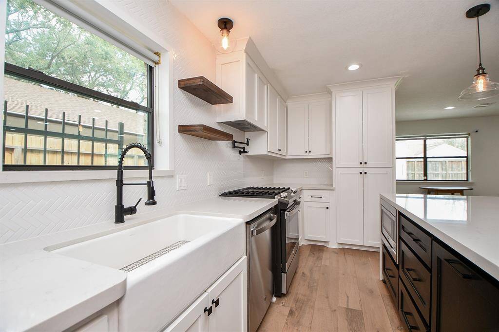 Charming farmhouse sink adds rustic elegance to this modern kitchen.
