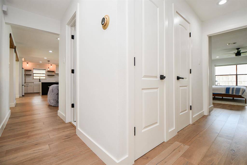 Bright and inviting hallway with modern finishes and stylish wood flooring, seamlessly connecting living spaces.
