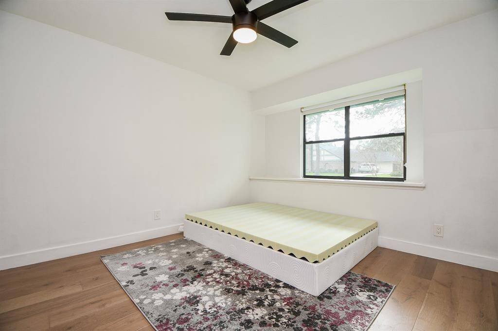 Bright and airy bedroom featuring sleek hardwood floors and a large window inviting natural light.