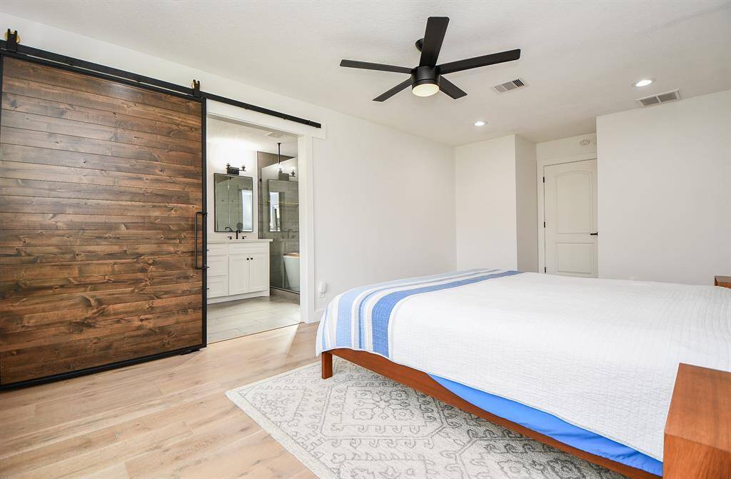 Luxurious bath with stylish barn door entrance.