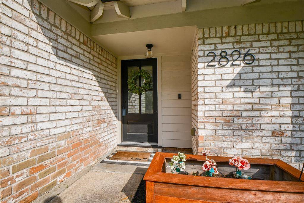 Inviting entrance with a charming brick facade and stylish front door, setting the tone for a warm welcome.