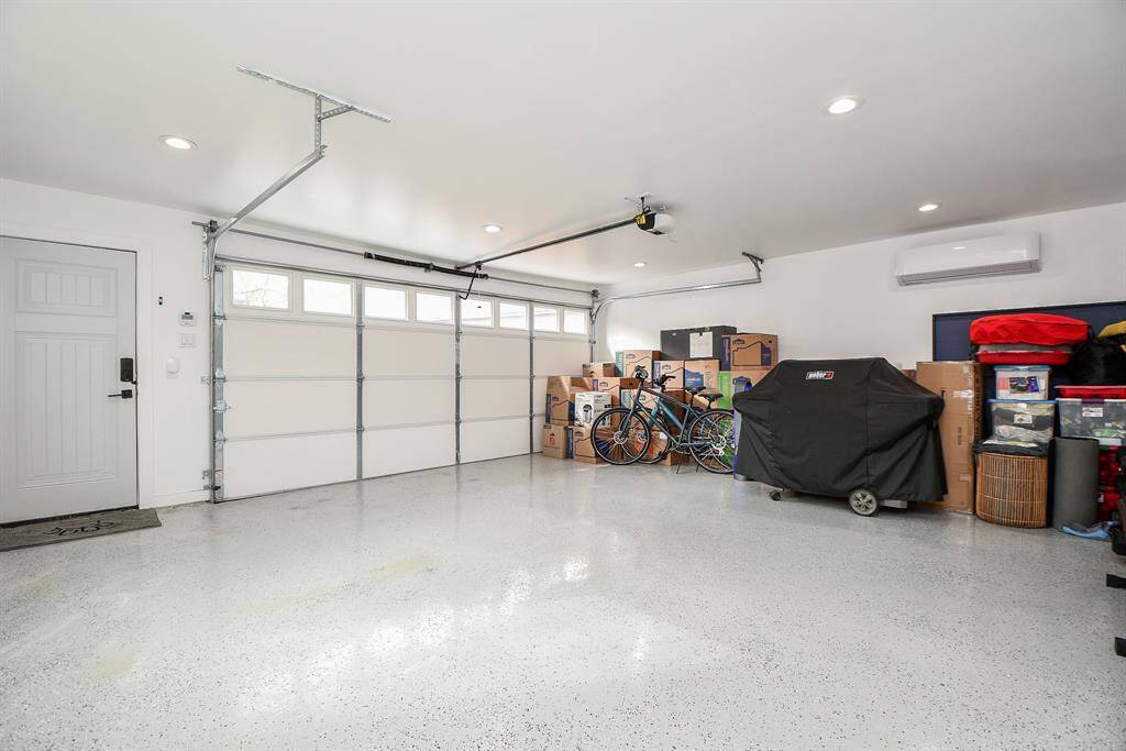 Enjoy a finished garage featuring a sleek epoxy floor, efficient split AC unit, full insulation, and bright lighting.