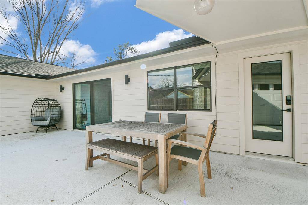 Spacious back patio perfect for outdoor dining and relaxation, featuring modern seating and a serene atmosphere.