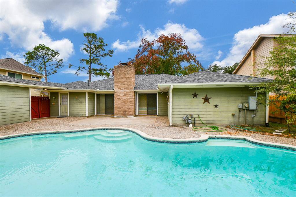 Spacious backyard with a refreshing pool and charming patio area, perfect for relaxing and entertaining.
