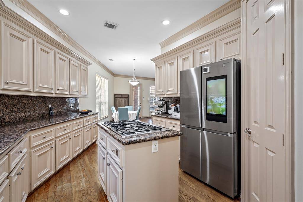 This handsome kitchen with s/s appliances, crown molding, island gas stove and recessed lighting is spacious.  Just look at all those cabinets!  Note that current ref will be switched out with another one.