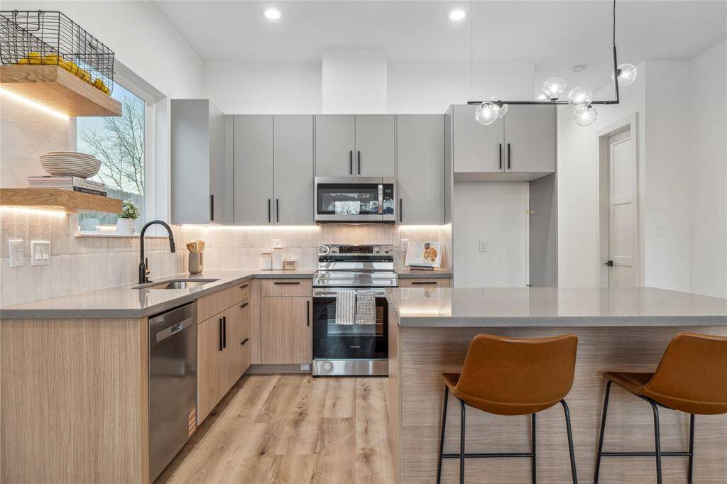 These two tone cabinets tones give a warm earthy feel to this stunning kitchen with floating shelves and undermount LED lighting.