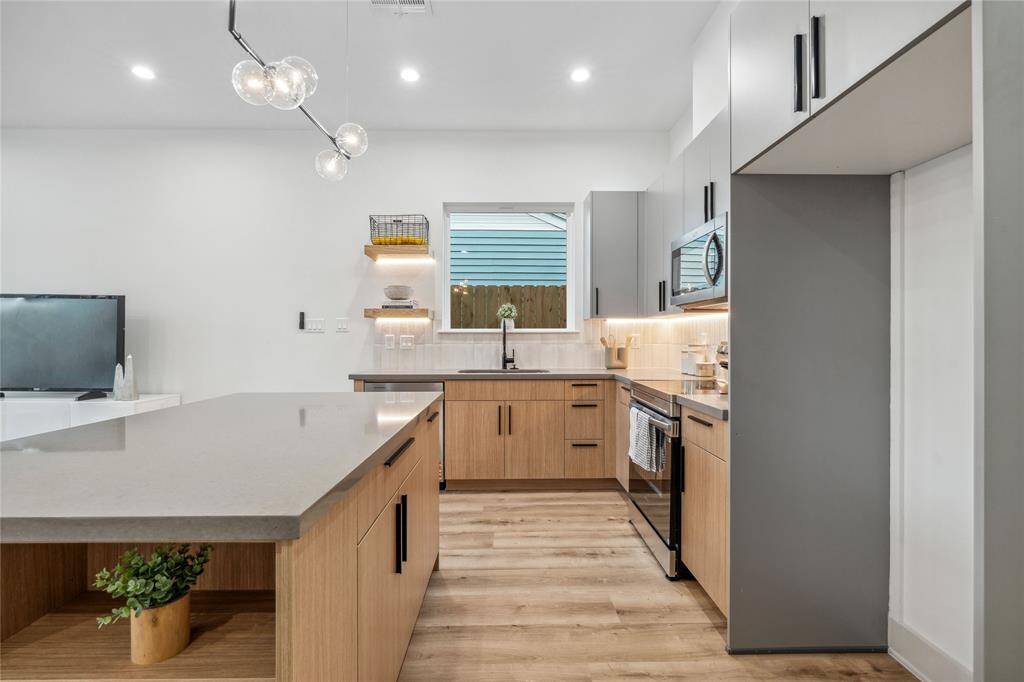 The kitchen displays a stunning sputnik inspired pendant that adds to the modern feel of this duplex.