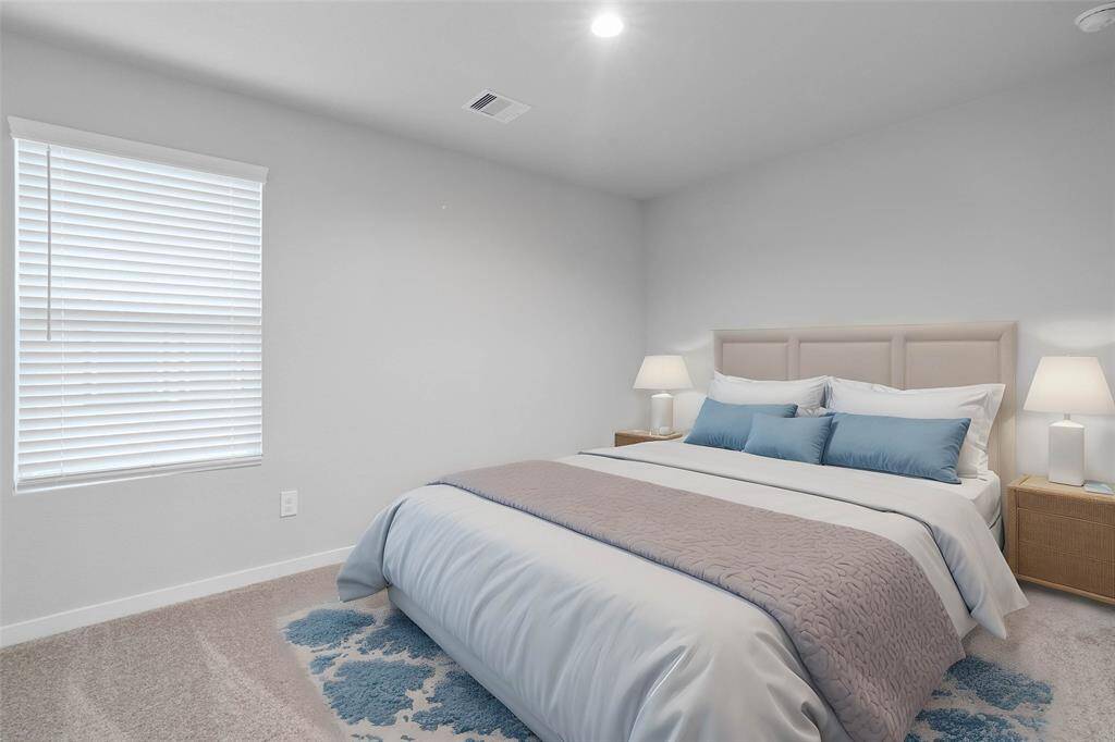 This secondary bedroom features custom paint, plush carpet, and a large window with privacy blinds!