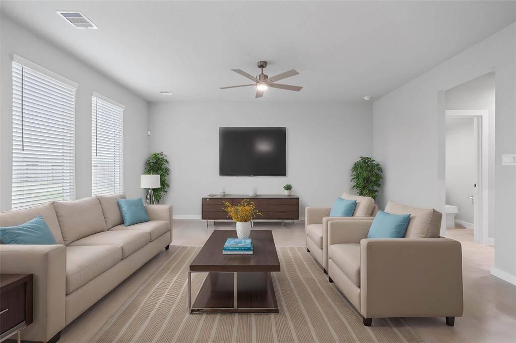 This light and bright spacious family room is the perfect layout for entertaining or just relaxing! Whether it's simply a night in or entertaining family and friends, this home has ample open space for everyone to enjoy! Featuring large windows with blinds, ceiling fan, and wonderful access to your gorgeous kitchen!