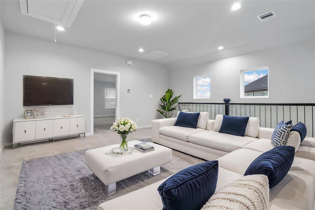 Come upstairs into this spacious second floor. This space features plush carpet, recessed lighting, custom paint, and wrought iron stair railing.