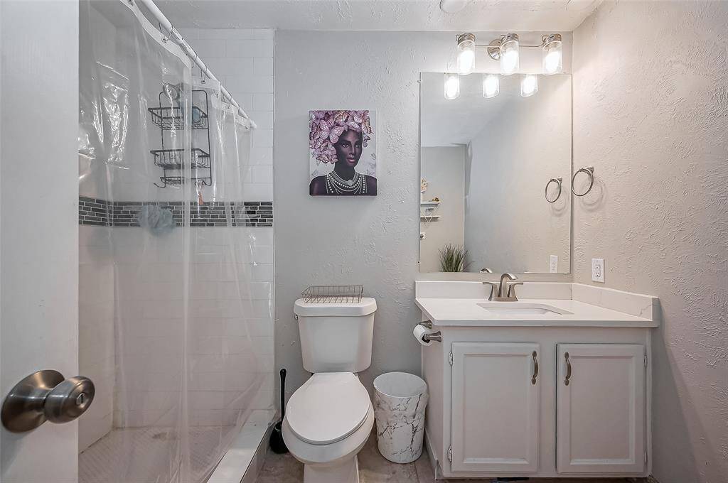 Primary bath featuring large, walk in shower and quartz countertop