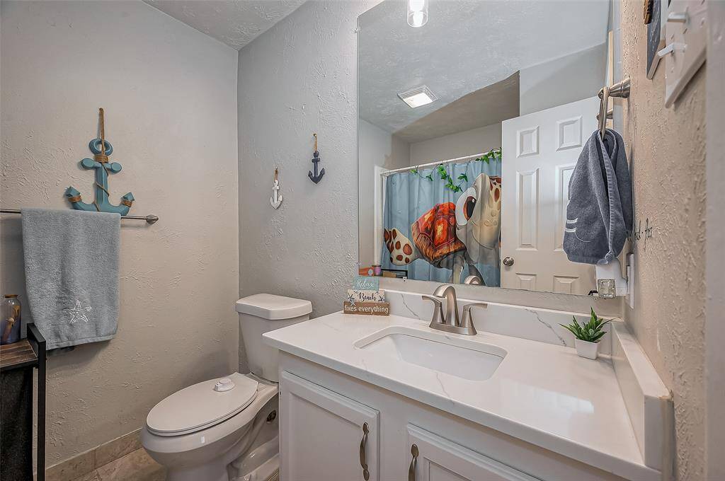 Secondary bathroom with shower/tub combo and quartz countertop