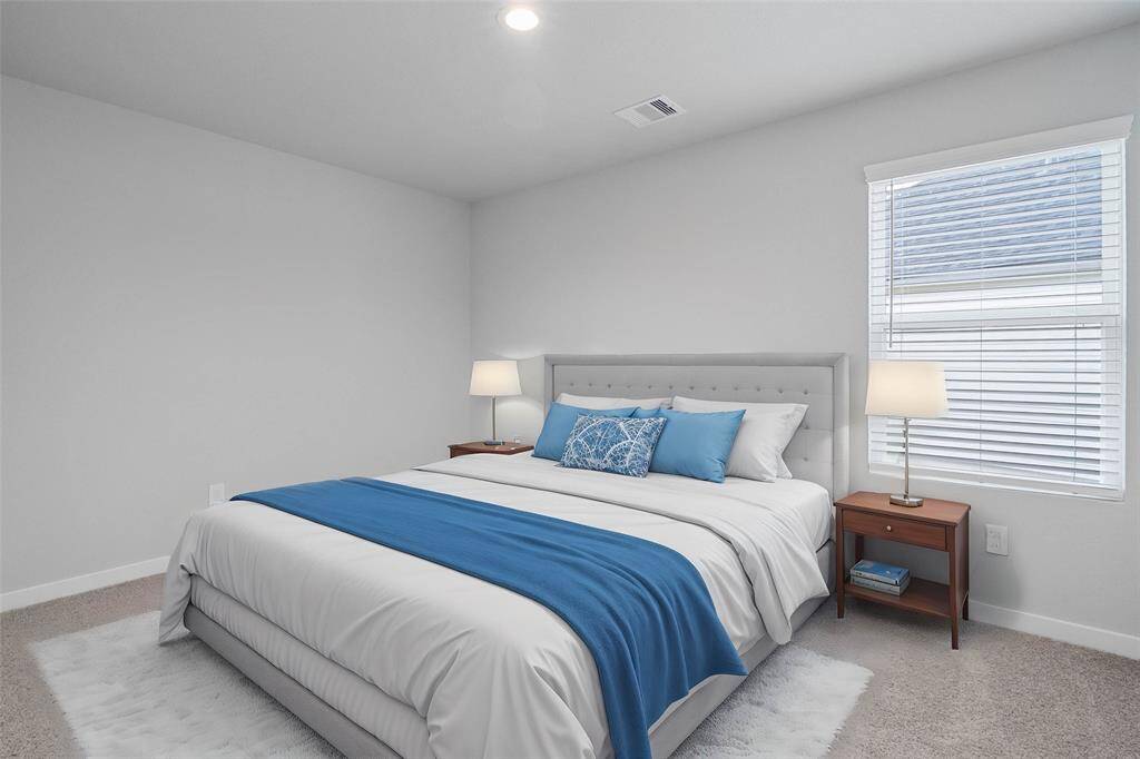 This secondary bedroom features custom paint, plush carpet, and a large window with privacy blinds!