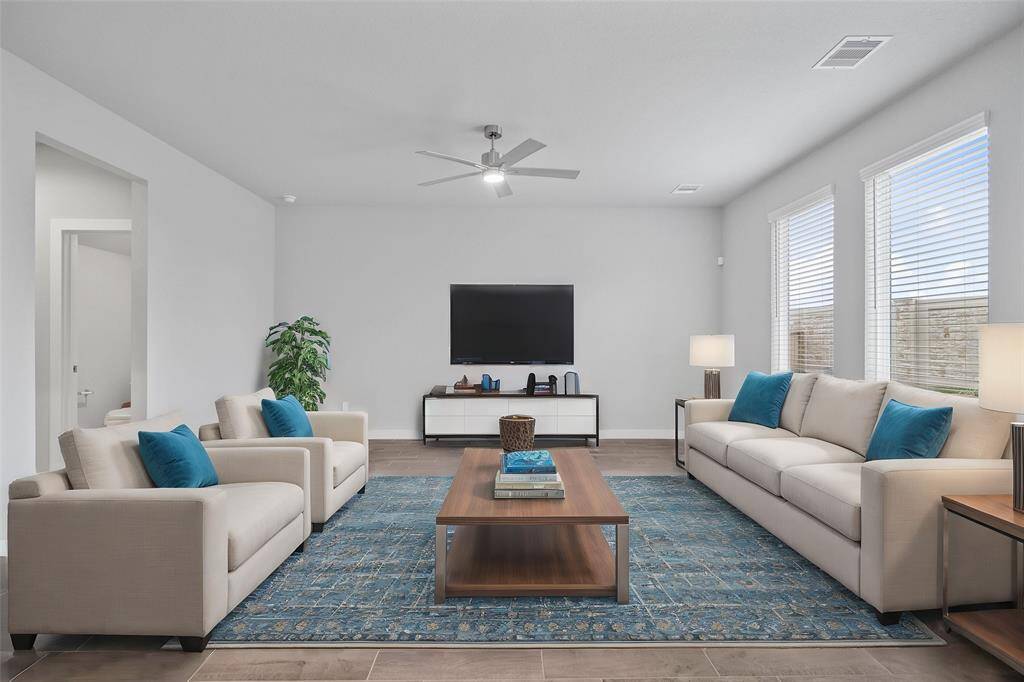 This light and bright spacious family room is the perfect layout for entertaining or just relaxing! Whether it's simply a night in or entertaining family and friends, this home has ample open space for everyone to enjoy! Featuring large windows, ceiling fan, and wonderful access to your gorgeous kitchen!