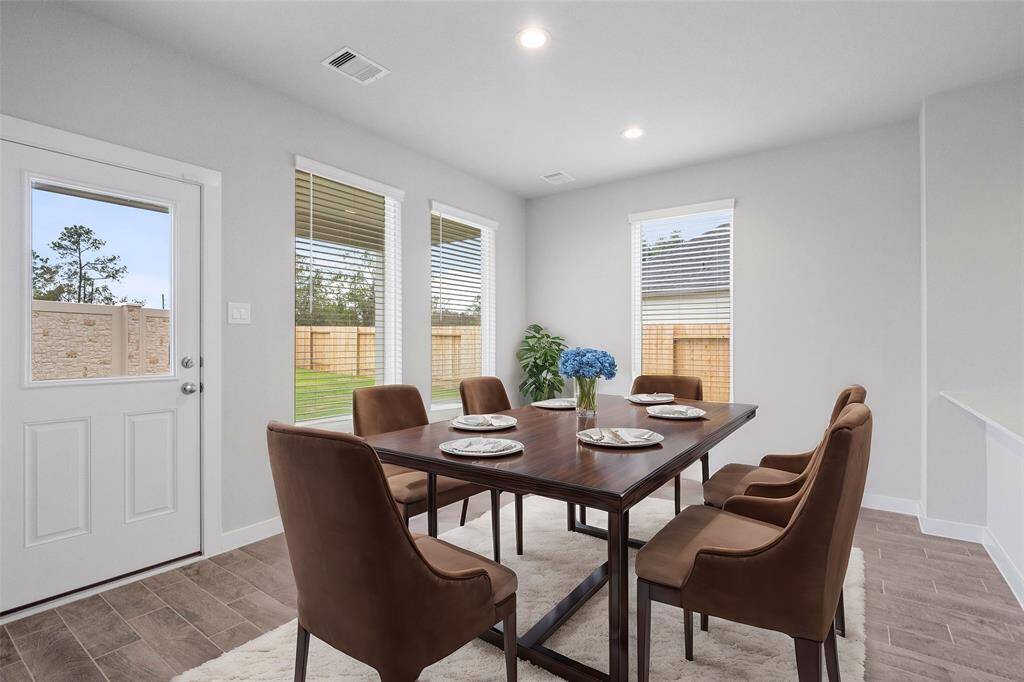 This lovely dining area is perfect for starting the day out on the right foot! This space showcases custom paint, recessed lighting, large windows adding to the ample natural light in the kitchen, and tile flooring!