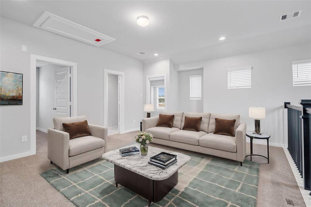 Come upstairs into this spacious second floor. This space features plush carpet, recessed lighting, custom paint, and wrought iron stair railing with view of first floor.