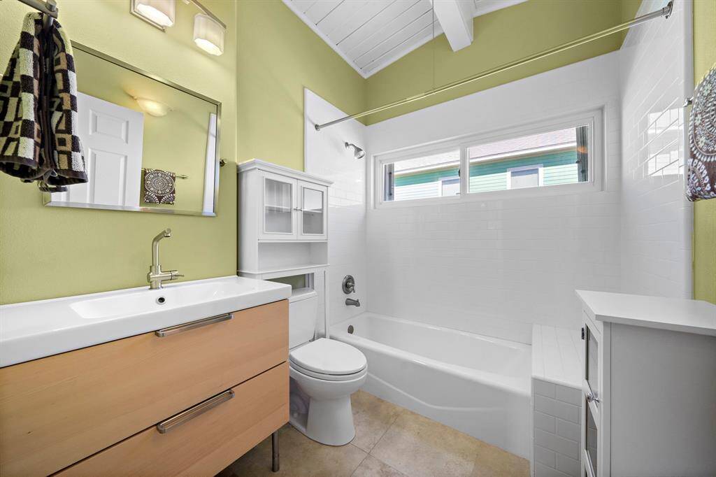 Wake up to a peek at the neighborhood and swaying palms from this sunlit bedroom. The layout comfortably accommodates a full-size bed and media setup.