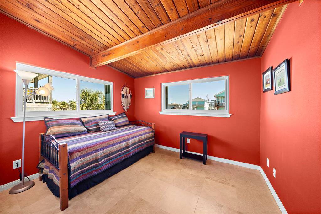 Painted in a warm terracotta tone, this flexible guest bedroom offers large closets and abundant natural light—ideal for a cozy retreat or office space.