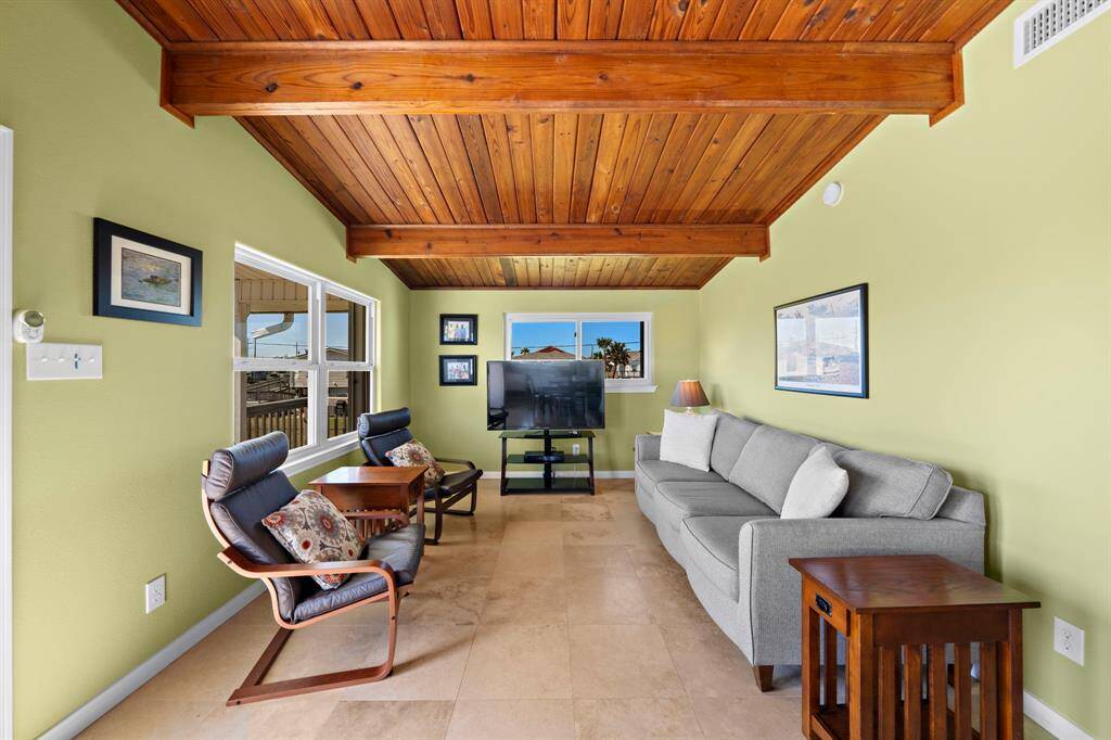 Another view of the home showcases the generous deck, fully fenced backyard, and ample green space—ideal for pets, gardening, or play.