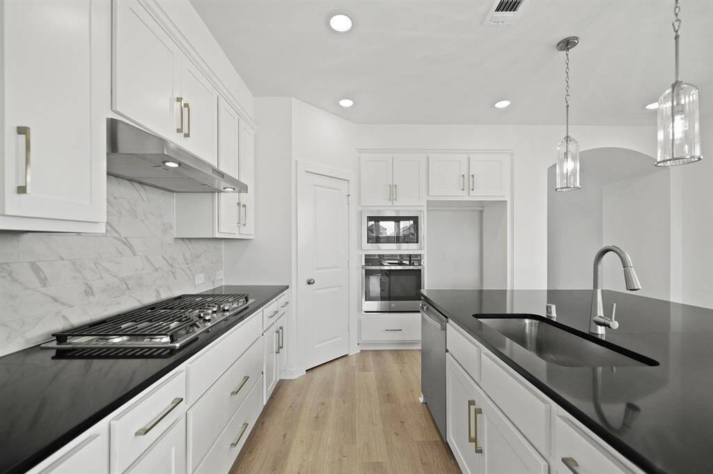 A beautiful white and black contrast color kitchen invites you to prepare amazing meals
