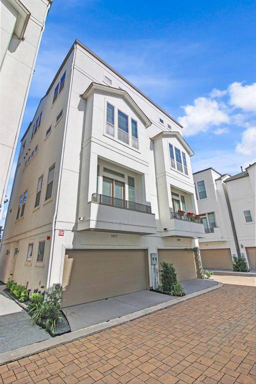 5421 Larkin Street is the townhome on the left. Stucco exterior and two car garage that opens to a paved shared driveway. The front door is down the sidewalk on the left.