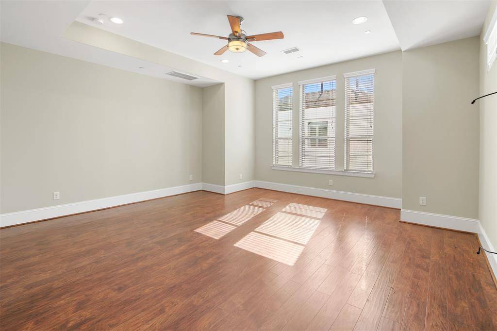 Spacious primary bedroom with a tray ceiling and huge windows for natural light.