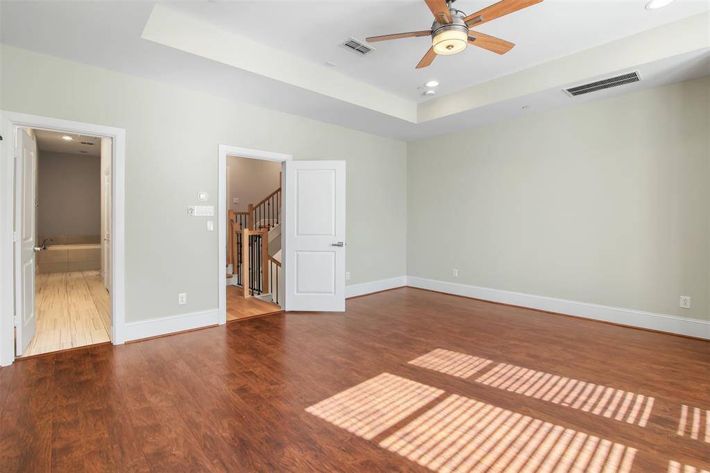 Opposite view of primary bedroom showing and the en suite bathroom entrance through the door on the left.
