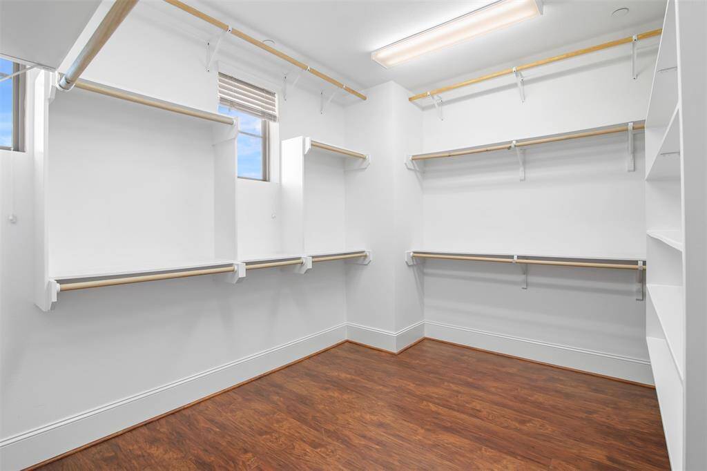 Very spacious primary bedroom closet with built in shelves. The closet wraps around to the right for even more space.