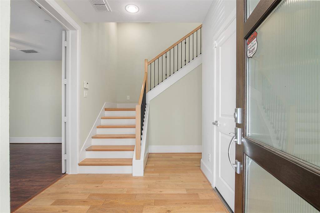 Walk in to the entryway with a secondary bedroom with an en suite bathroom to the left. Garage access is through the door to the right.