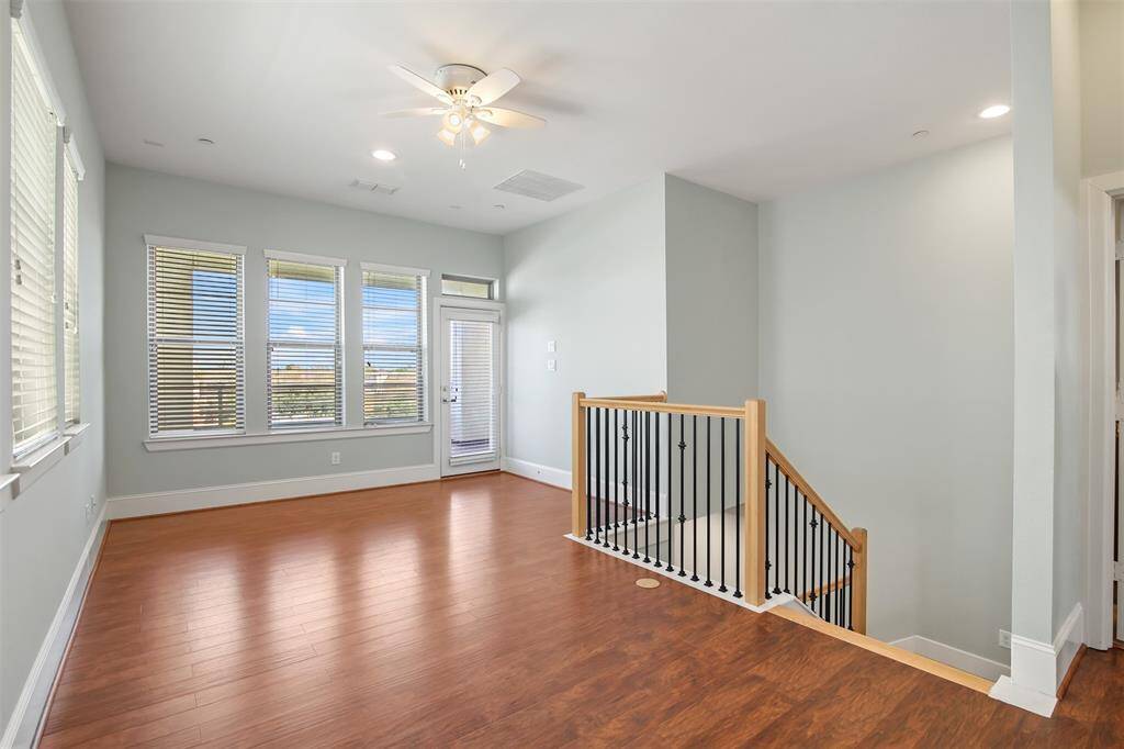 Opposite view of the game/media room. Lots of large windows offer so much natural light. The large covered balcony is through the the door in the back.