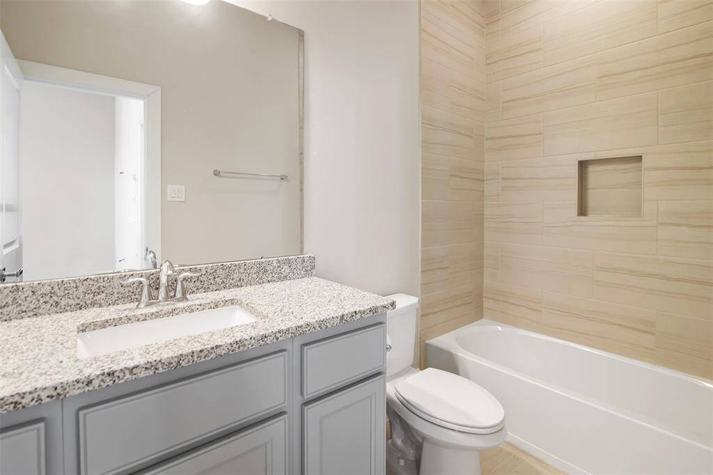 Second full bathroom located on the fourth floor with beautiful tile surround around the tub/shower combo, gorgeous and a spacious countertop with plenty of storage underneath.