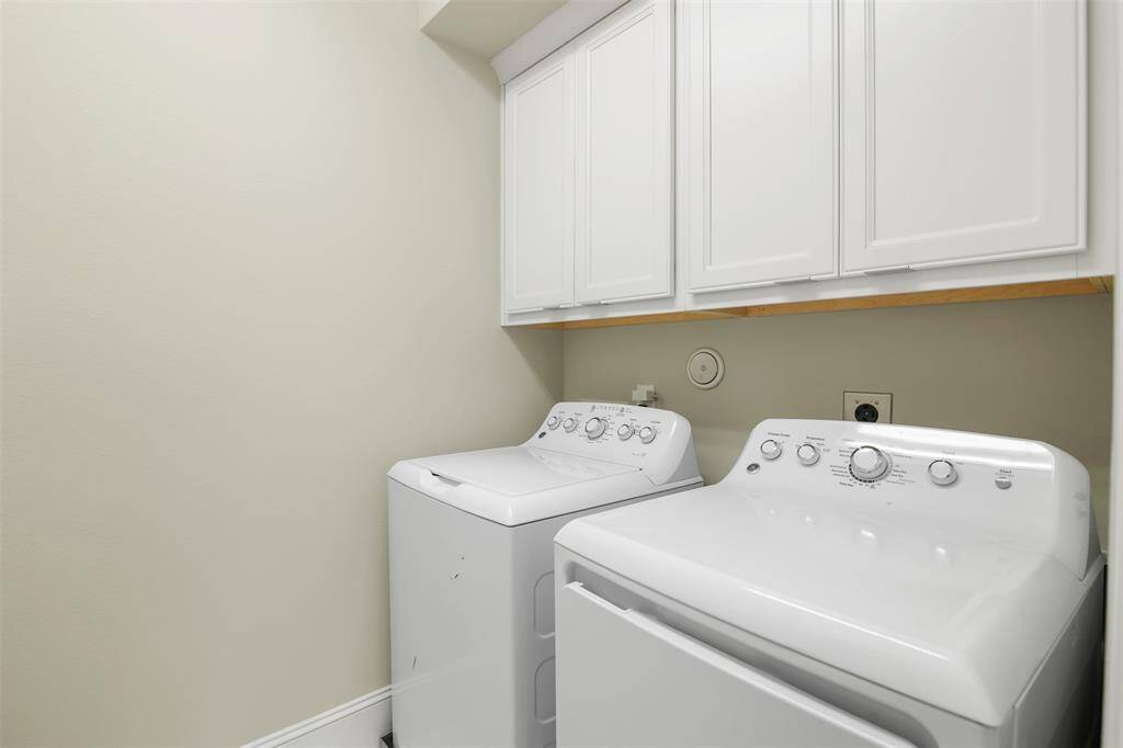 Laundry room with extra storage above. Washer and dryer convey with the property!