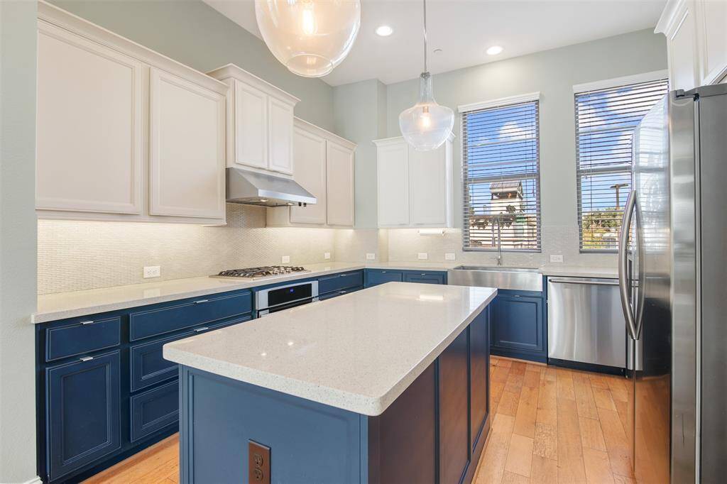 The kitchen features loads of storage space with some cabinets having pull out shelving inserts. There is a gas cooktop, farmhouse sink, modern pendant lights over the island that has even more storage space along with a built in microwave. Refrigerator conveys with the property!