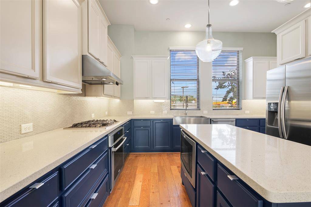 Beautiful shot of the kitchen, custom painted cabinets, modern backsplash, and modern countertops.