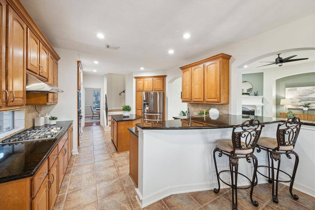 This spacious kitchen features an island with a breakfast bar, and a butler’s pantry for extra storage.