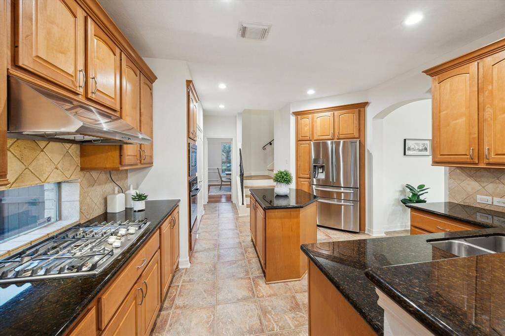 This kitchen is equipped with sleek stainless steel appliances, including a gas cooktop, perfect for the home chef.