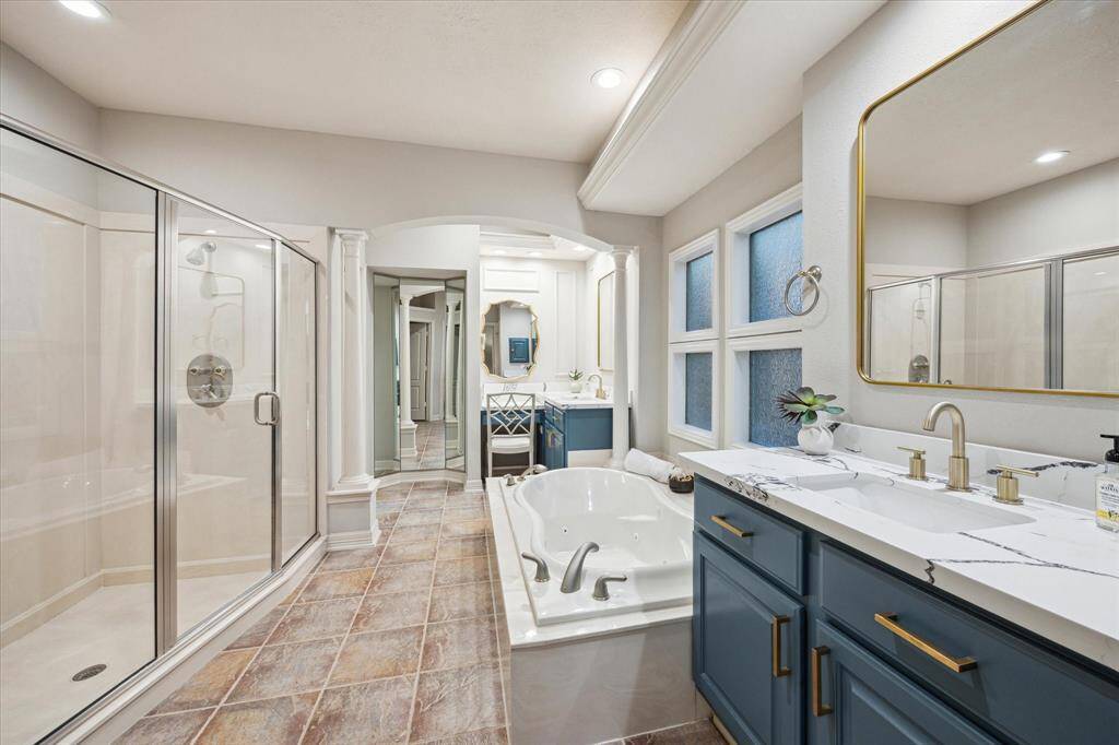 The updated primary bathroom is a true spa-like retreat, offering a soaking tub, a spacious walk-in shower, and dual vanities for added convenience. Thoughtfully redesigned with modern finishes.
