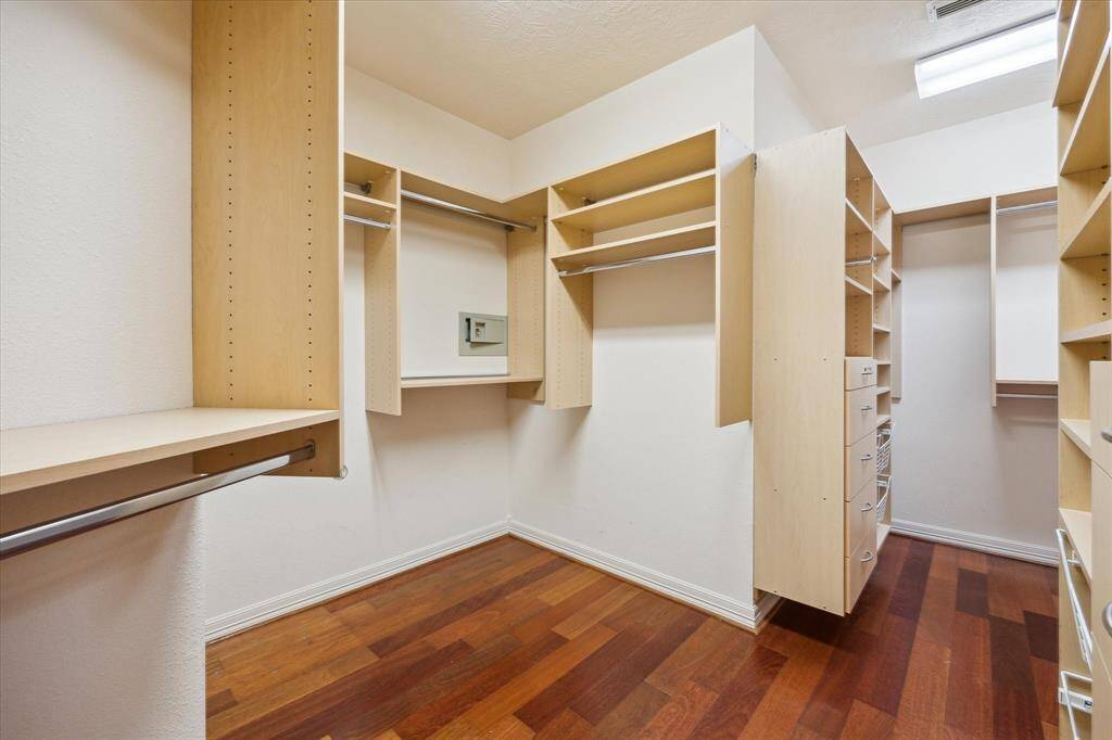 The expansive closet is a true organizational dream, featuring custom-built shelves, drawers, and both top and bottom hanging spaces.