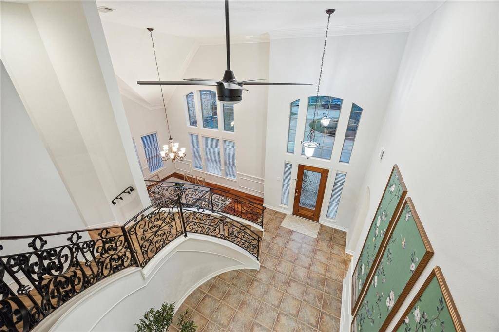 Stunning view from the second-floor landing, overlooking the elegant curved staircase and grand entry.