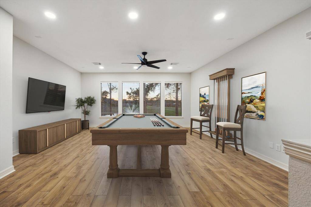 The spacious game room upstairs offers an inviting atmosphere, complete with breathtaking lake views. Large windows frame the serene water, creating a perfect backdrop for entertainment or family fun. *This photo has been virtually staged.