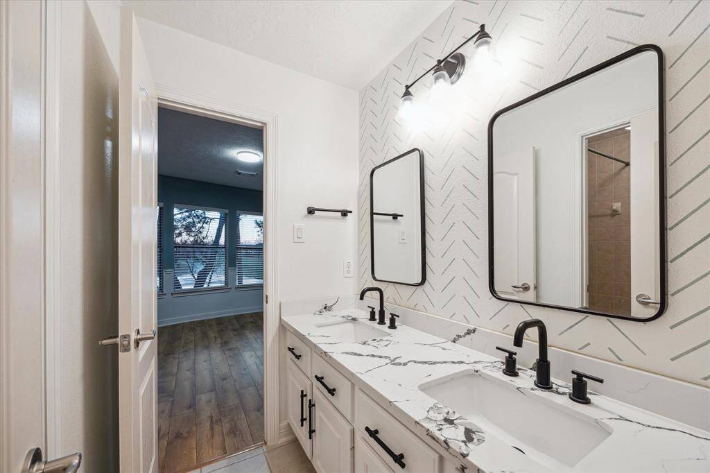 The upstairs Jack and Jill bathroom has been beautifully updated with modern finishes and sleek design.