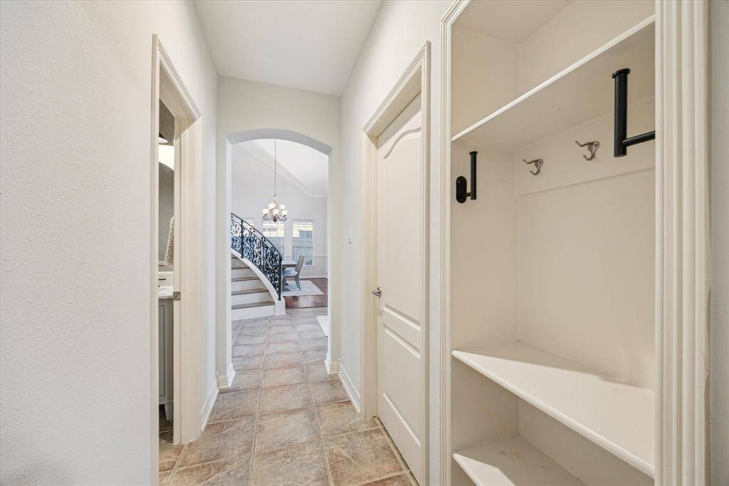 This mudroom nook by the garage entry offers built-in shelving, hooks, and ample storage for coats, shoes, and bags.