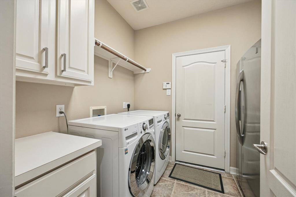 The utility room offers plenty of room for both laundry tasks and additional storage, including a dedicated space for a refrigerator.
