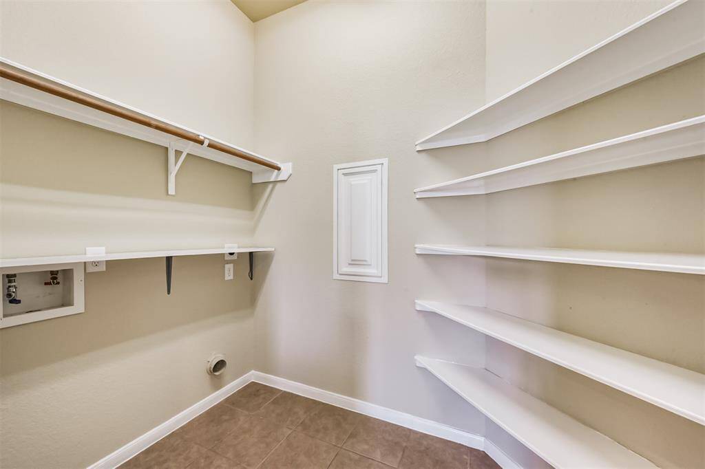 Spacious laundry room with built-in shelving and ample storage—perfect for organizing and managing household tasks.