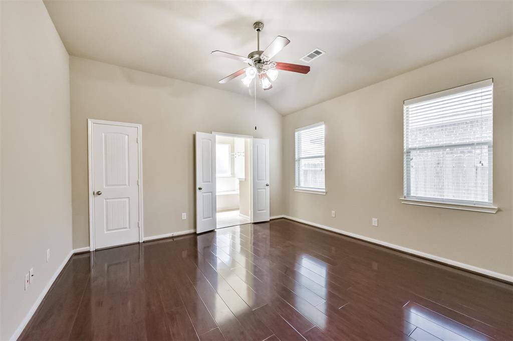 Spacious primary bedroom with a ceiling fan for added comfort.