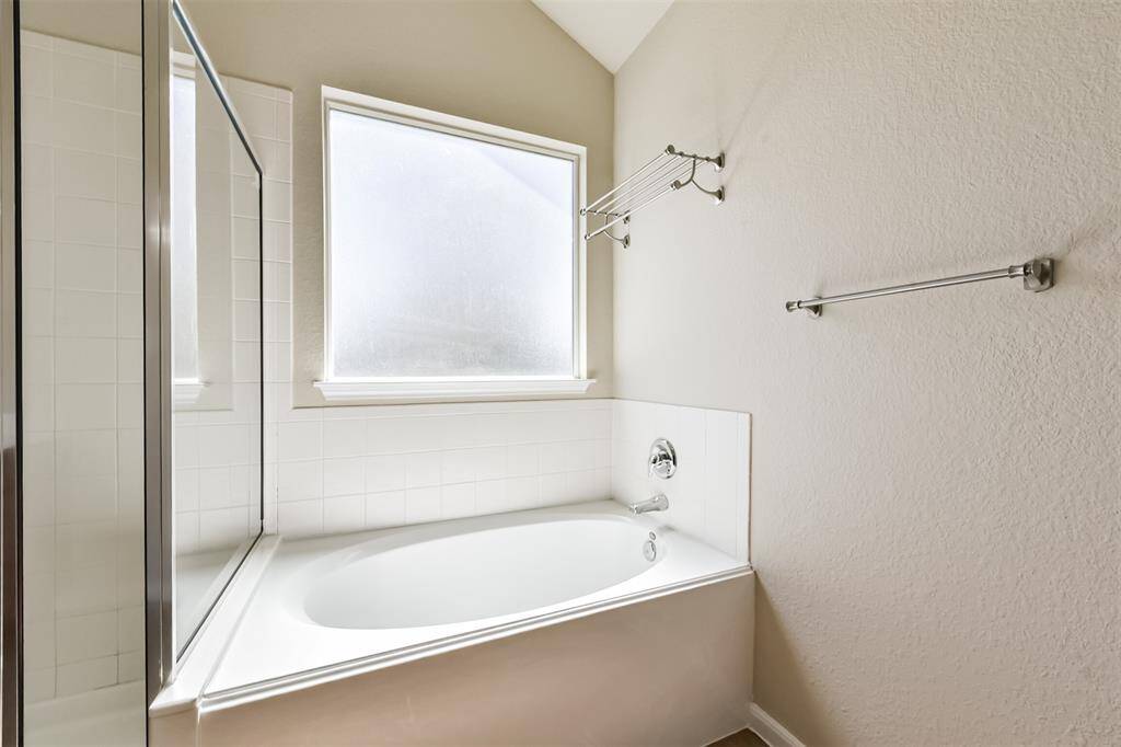 Luxurious primary bathroom featuring a separate shower and soaking tub for ultimate relaxation.