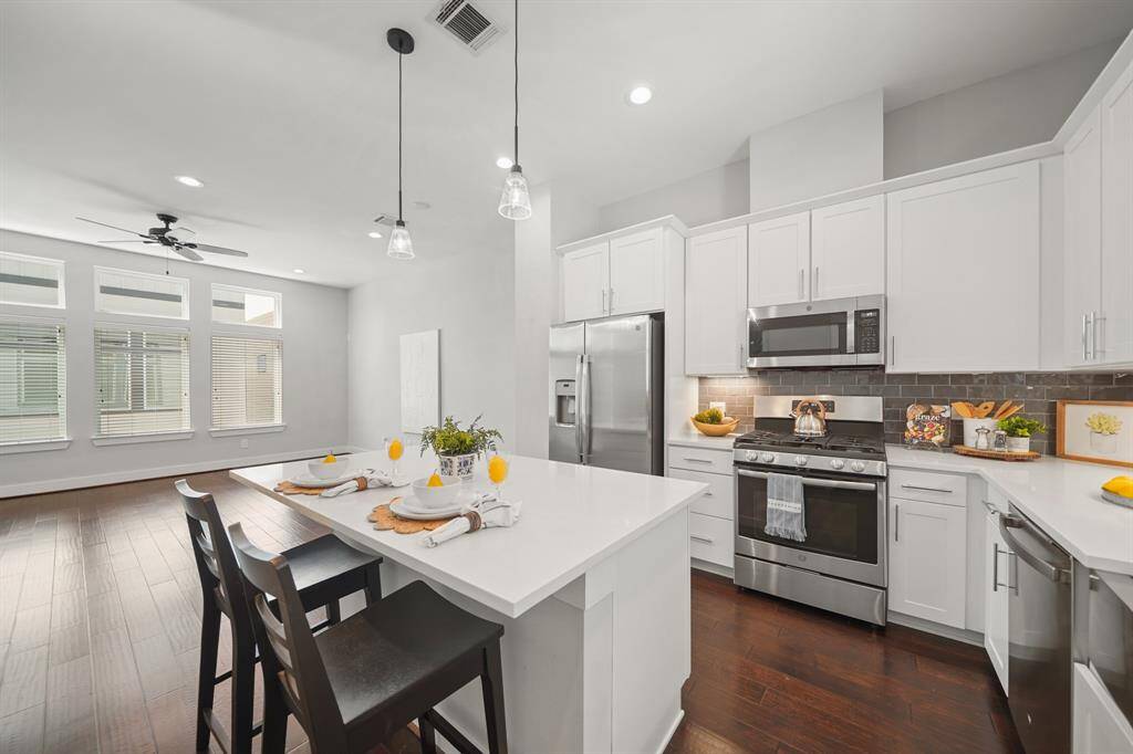 The GE stainless steel appliance package includes a 5-burner gas range with conventional oven below, a built-inmicrowave oven with ventilation and lighting above and a dishwasher. As an added bonus, the stainless steel refrigerator with door mounted ice & water dispenser remains with the home.