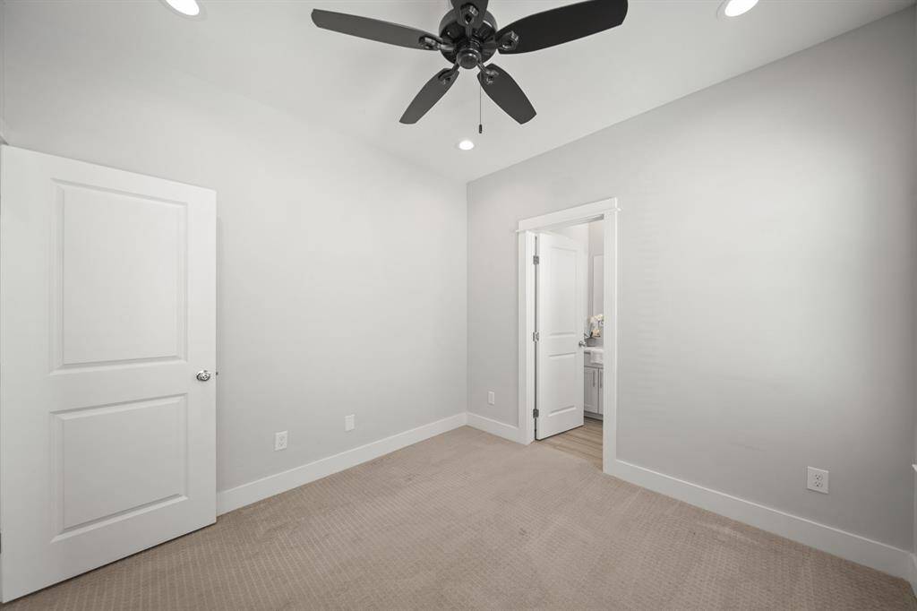 A view of the secondary bedroom with the ensuite bath in the background.
