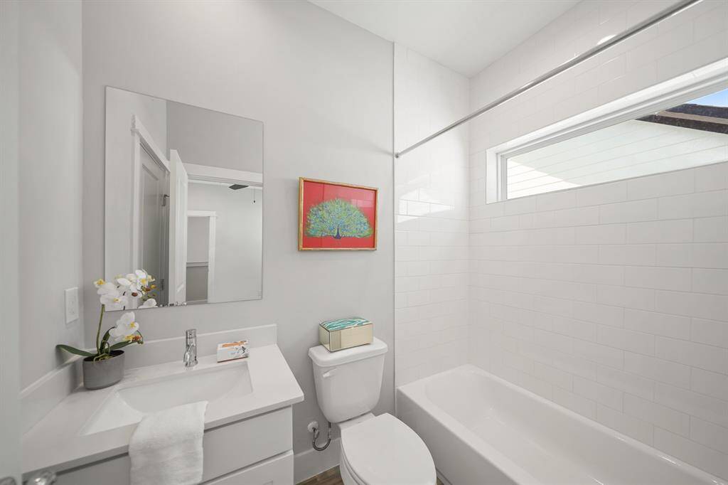 The ensuite bath includes recessed lighting, painted Shaker-style cabinets with quartz counter top and under-mount sink, wall mounted mirror, a subway tile surrounded combination tub/shower with fixed glass window above and 12" x 24" tile flooring. Included is a wardrobe storage closet.