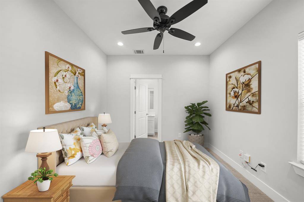 Located off the foyer on the first level of the home, the third bedroom includes an ensuite bath. This photo has been virtually staged.